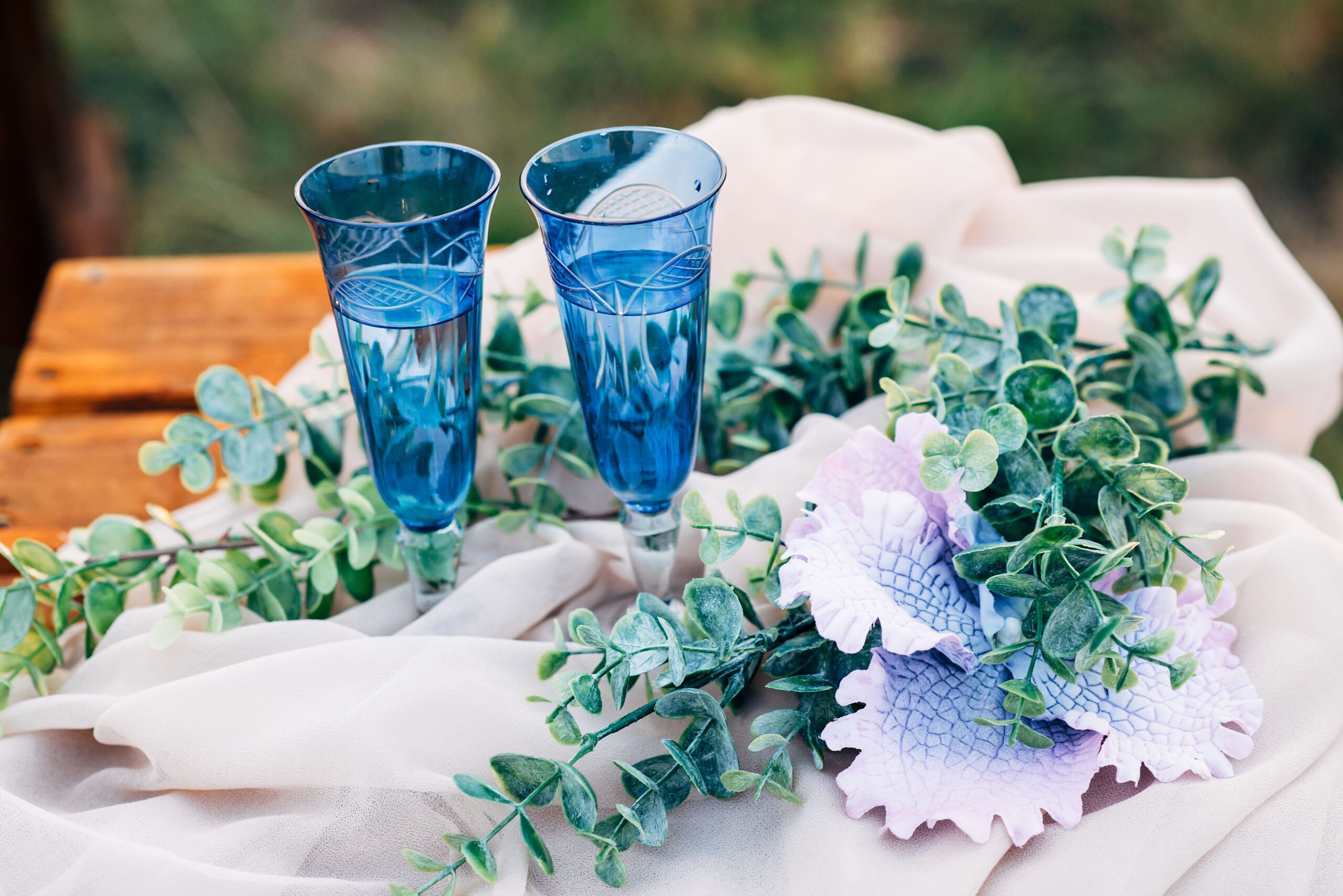 Floral Geschmückter Hochzeitstisch mit blauen Champagnergläsern aus Kristall