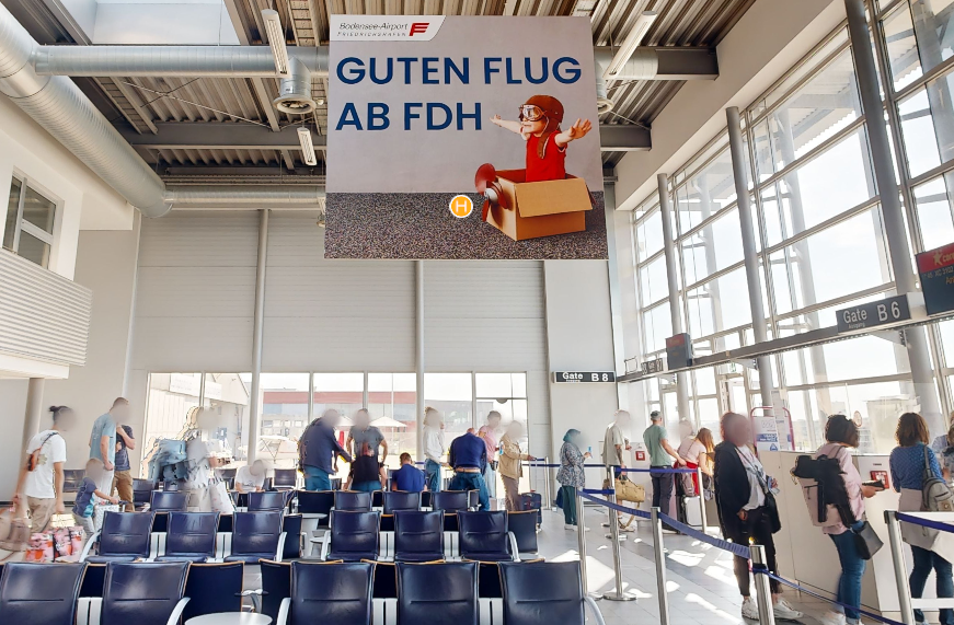 Gatebereich im Flughafen mit Werbefläche, die von der Decke hängt