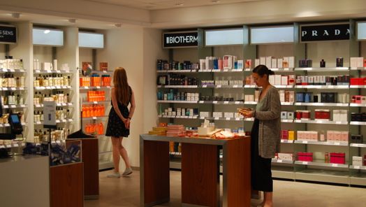 Duty Free Shop Regale und 2 Personen, die im Duty Free Shop laufen und stöbern