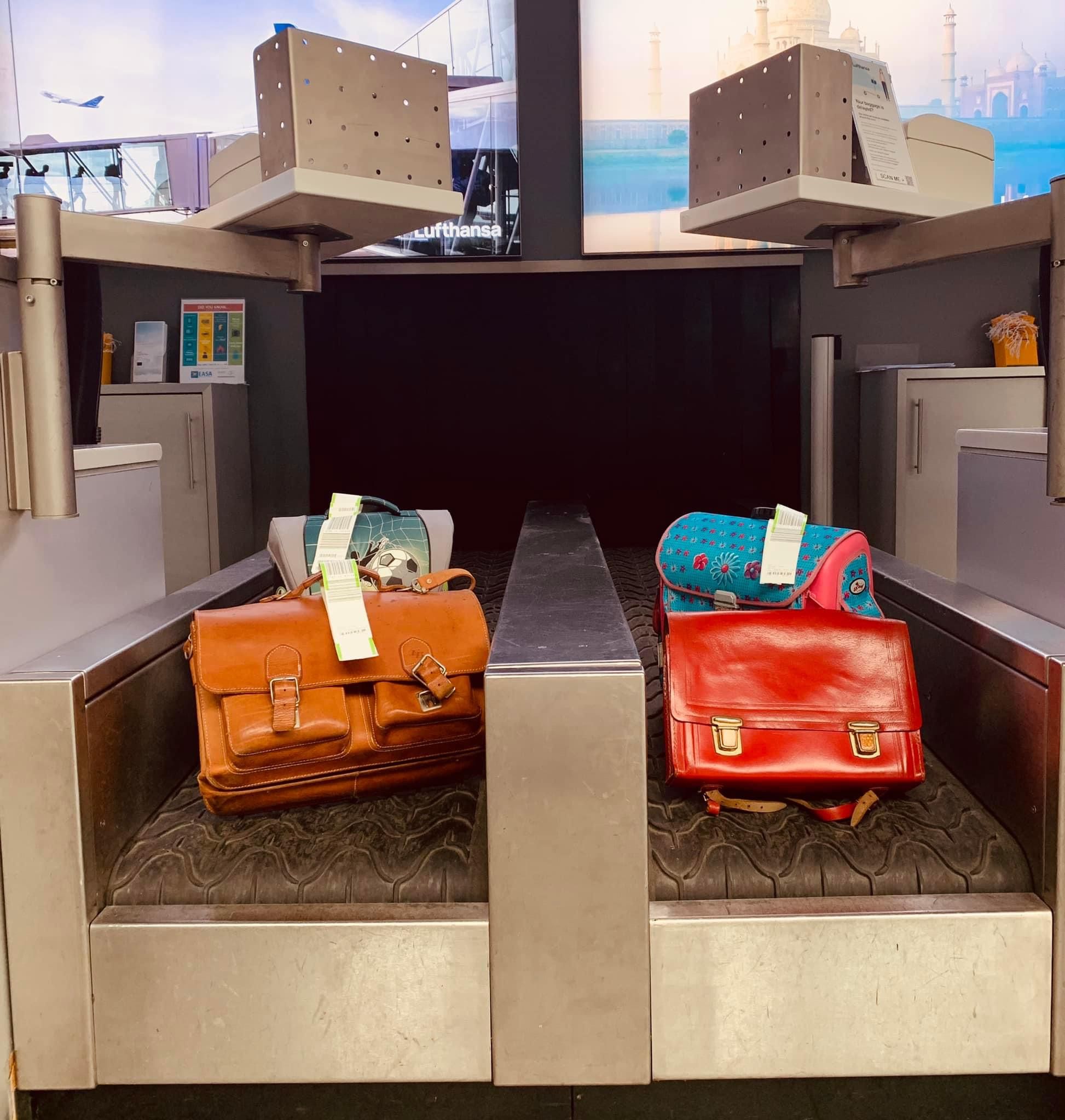 Schulranzen auf dem Gepäckband am Check-In des Flughafens