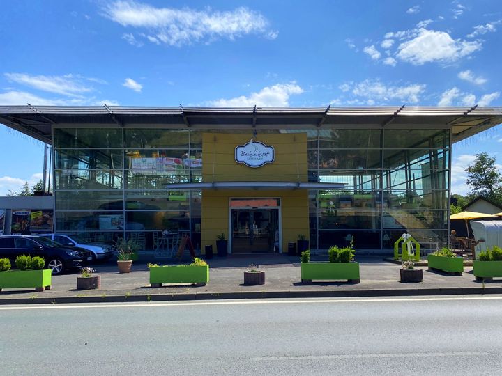 Gebäude und Eingang der Backwertstatt Schwarz bei sonnigem Wetter.