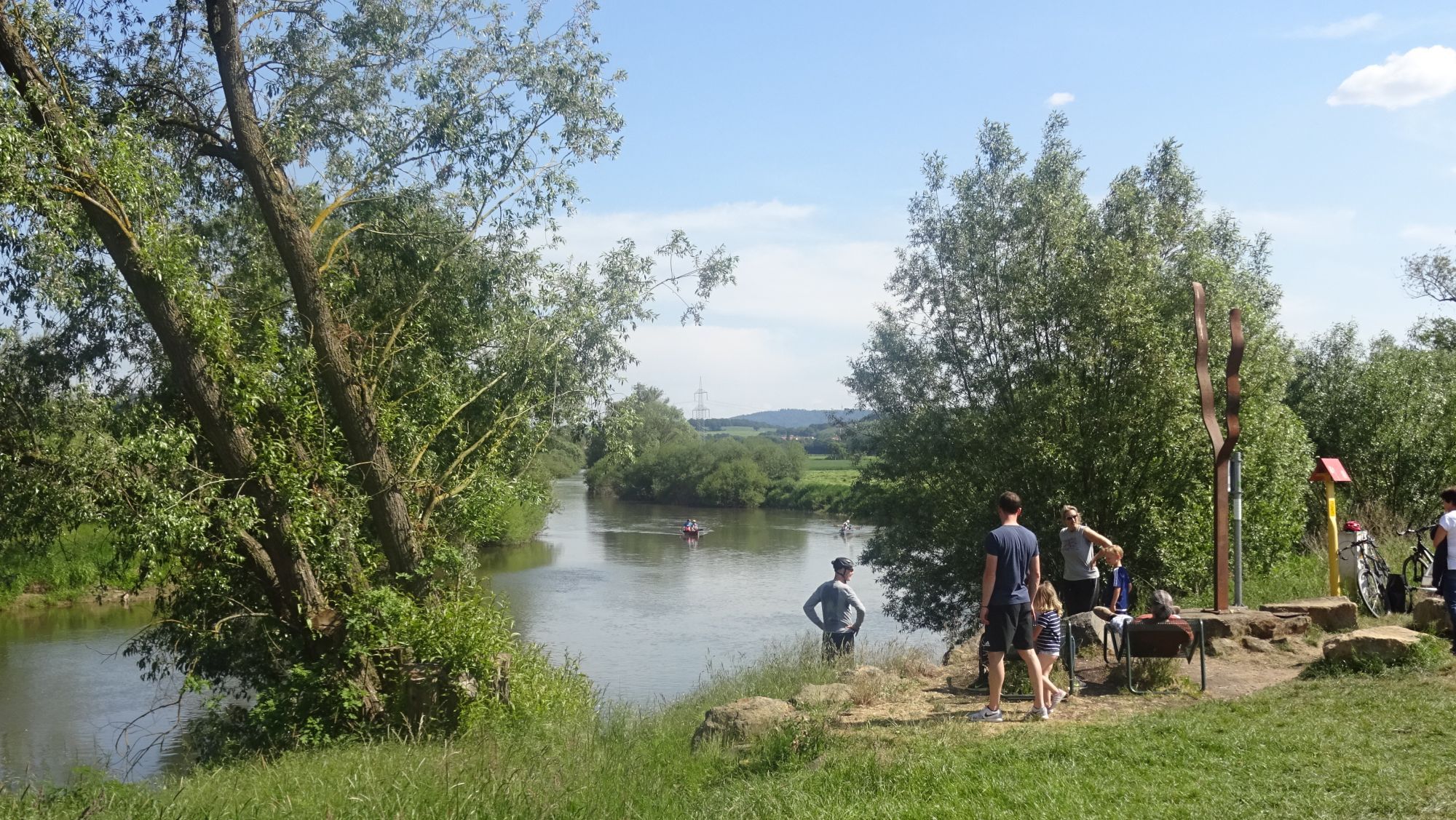 Eine Gruppe von Personen, die sich an einem sonnigen Tag am Fluss ausruht