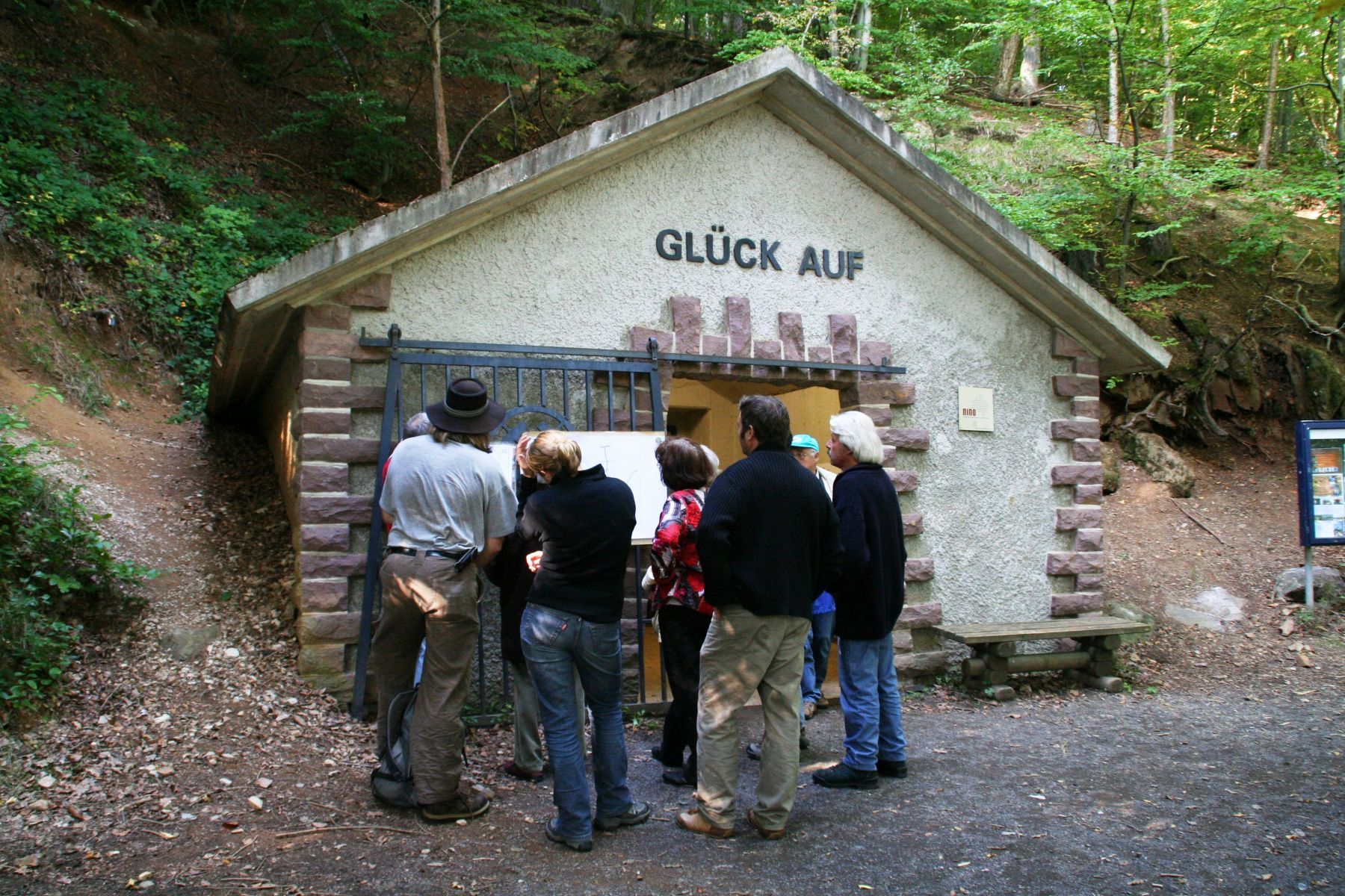 Blick auf den Eingang zum Bergwerk in Bergfreiheit mit einer Gruppe von Menschen davor