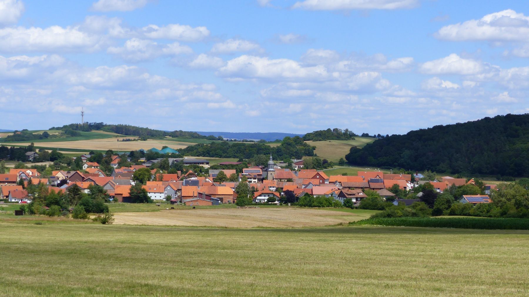 Blick über den Stadtteil Braunau mit den Feldern im Vordergrund und Braunau im Hintergrund.