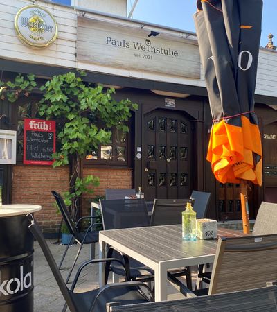 Außenansicht des Eingangsbereichs und der Terrasse der Weinstube Pauls Weinstube