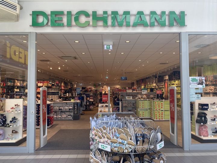 Offener Eingangsbereich von Deichmann mit Blick in das Geschäft in der Fürstengalerie. Vor dem Eingang stehen Körbe mit Hausschuhen.