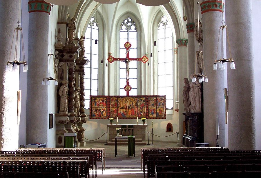Der Innen- und Altarbereich der Stadtkirche Bad Wildungen wird gezeigt. Dabei steht der berühmte Flügelaltar von Conrad von Soest im Mittelpunkt des Bildes.