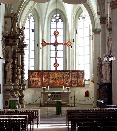 Der Innen- und Altarbereich der Stadtkirche Bad Wildungen wird gezeigt. Dabei steht der berühmte Flügelaltar von Conrad von Soest im Mittelpunkt des Bildes.