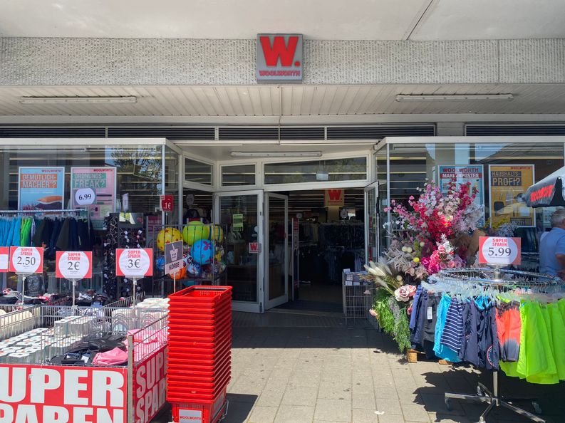 Blick auf den Eingang des Woolworth in Bad Wildungen bei sonnigem Wetter.