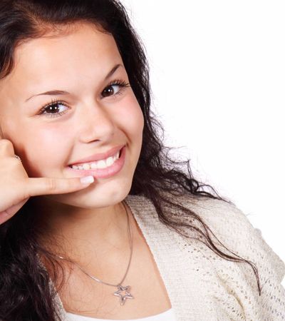 Eine Frau die mit einer Geste zeigt, dass sie angerufen werden will.