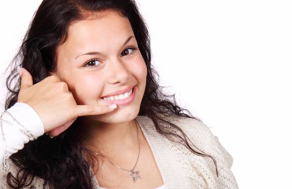 Eine Frau die mit einer Geste zeigt, dass sie angerufen werden will.