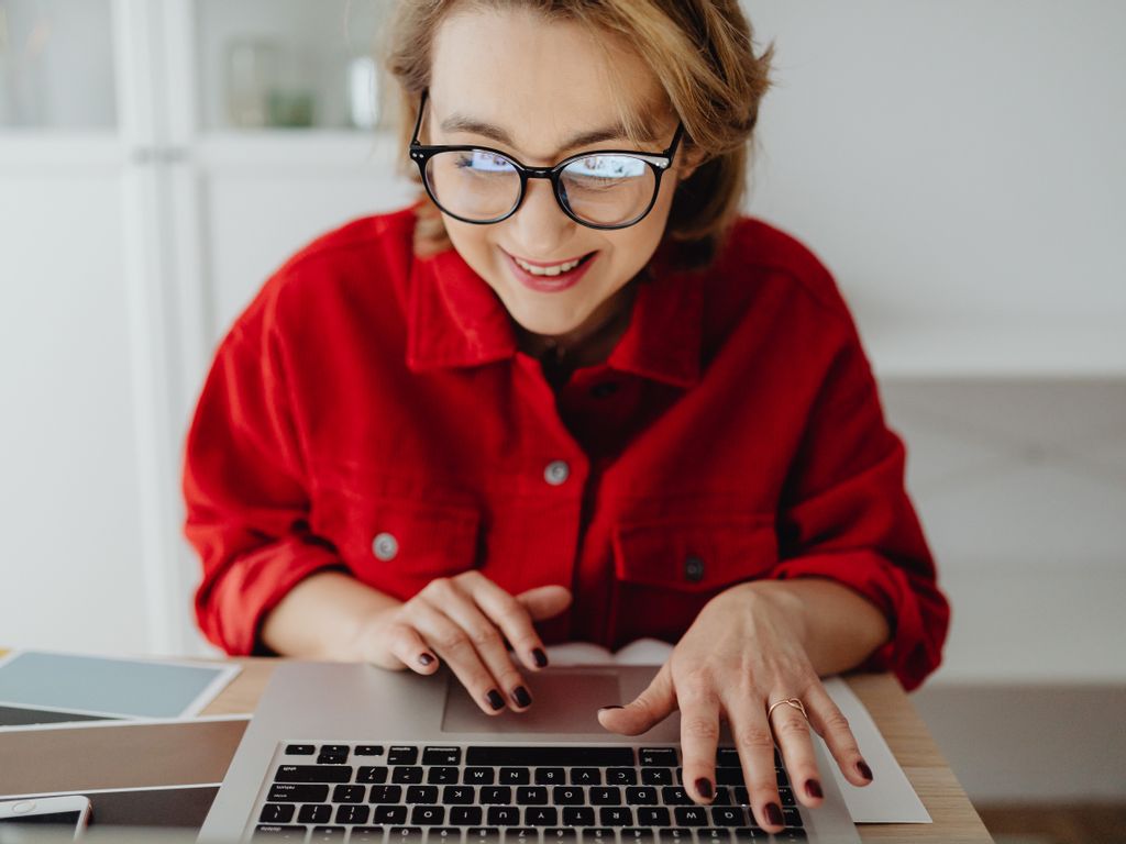 Blick von Vorne auf eine Frau die an einem Notebook arbeitet