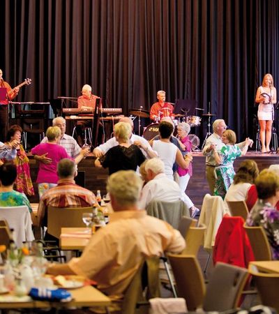 Tanztee in der Wandelhalle Bad Wildungen. Menschen tanzen zur Musik des Bad Wildunger Kurorchesters.