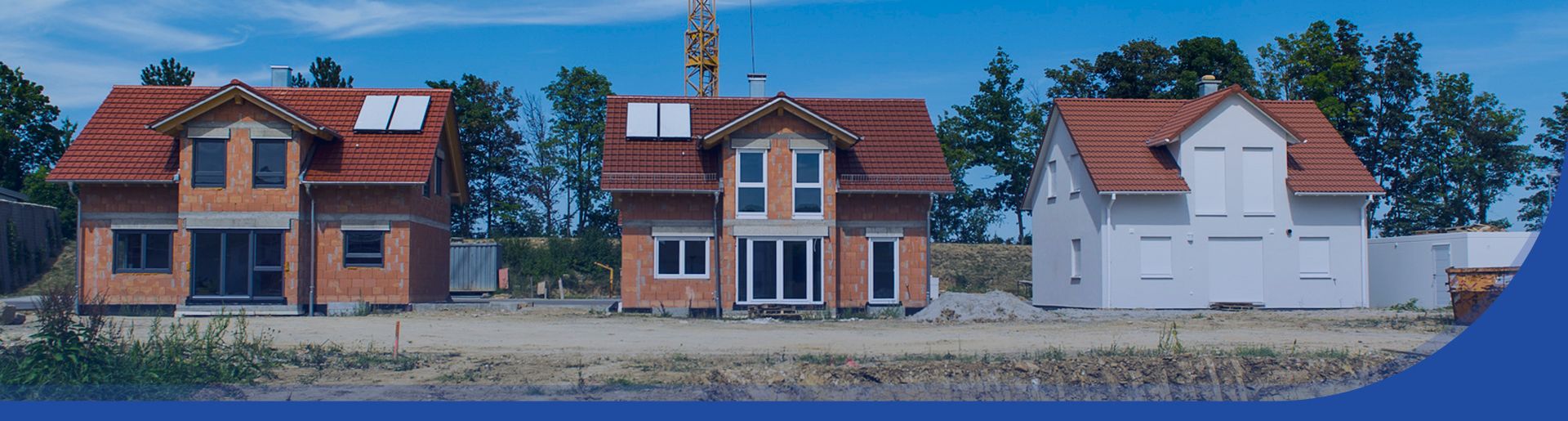 Blick auf eine Baustelle mit 3 neu gebauten Wohnhäusern