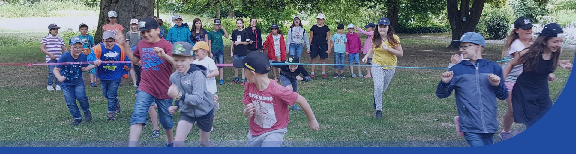 Kinder die miteinander auf einer Wiese spielen