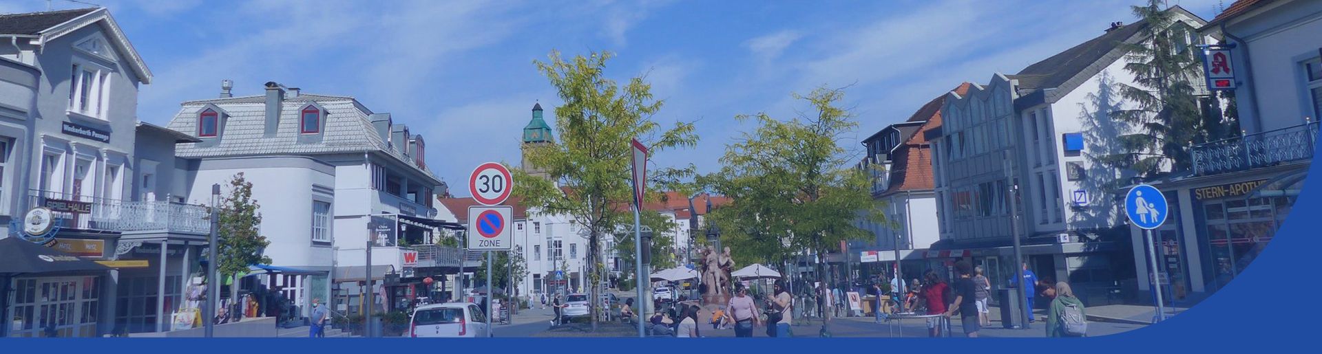 Blick auf die Brunnenstraße und deren Läden. Viele Leute bummeln durch die Stadt