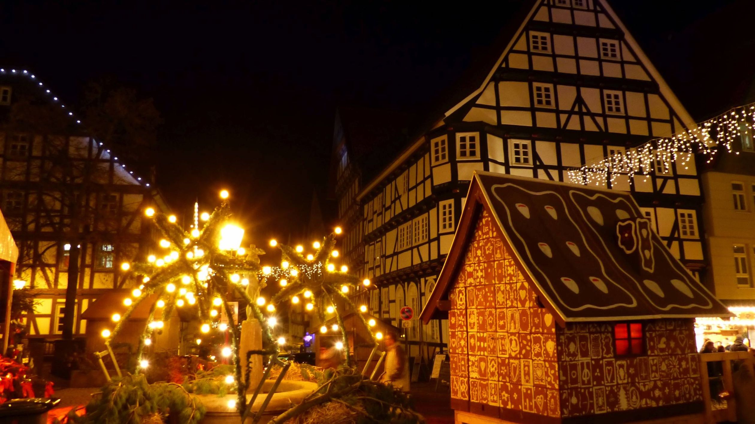 Bad Wildunger Weihnachtsmarkt am Abend mit Blick auf Fachwerkhäuser, leuchtende Dekoration und das Lebkuchenhaus.