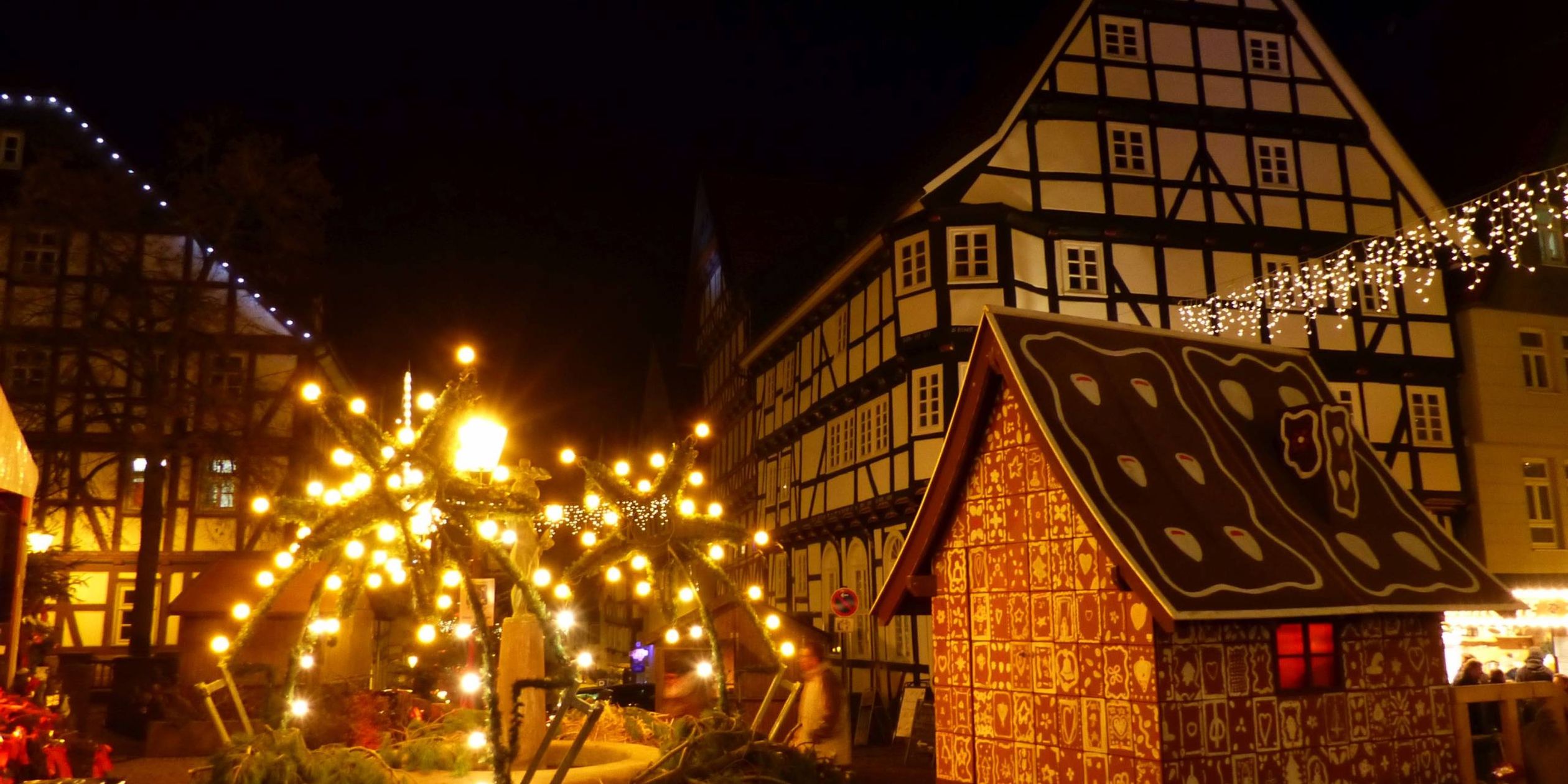 Bad Wildunger Weihnachtsmarkt am Abend mit Blick auf Fachwerkhäuser, leuchtende Dekoration und das Lebkuchenhaus.