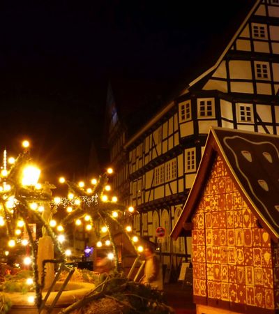 Bad Wildunger Weihnachtsmarkt am Abend mit Blick auf Fachwerkhäuser, leuchtende Dekoration und das Lebkuchenhaus.