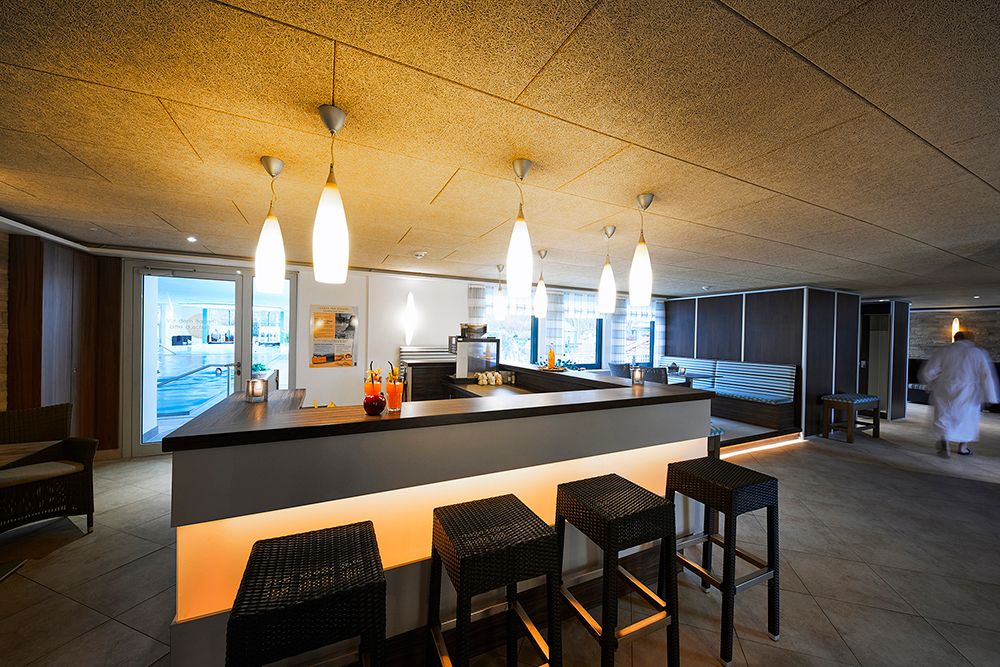 VitalBar des Goebel's Hotel AquaVita mit dem Blick auf die Bar. Im Hintergrund ist durch eine Glastür der Schwimmbereich zu sehen.