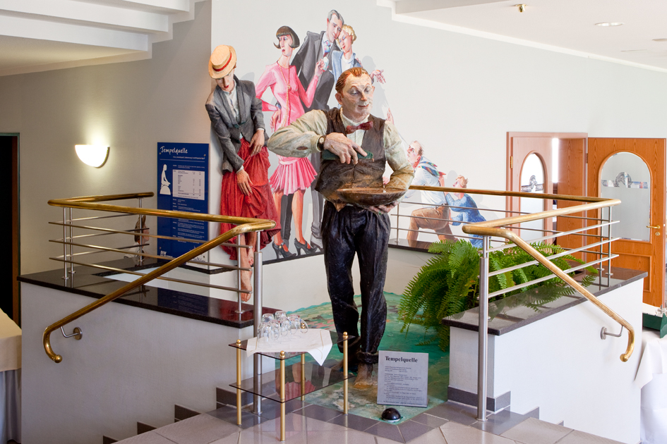 Blick auf eine Figur, die wie ein Kellenr aussieht im Eingangsbereich des Goebels Hotel Aqua Vita in Reinhardshausen. Hier kann man die Tempelquelle Bad Wildungen probieren.