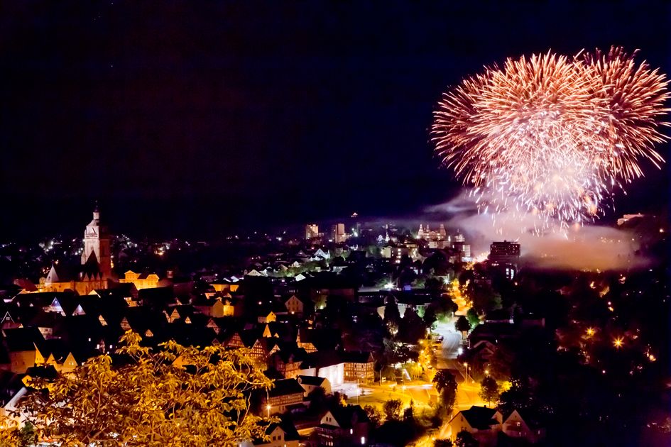 Blick über Bad Wildungen bei Nacht. Links ist die Stadtkirche zu sehen und rechts ein Feuerwerk.