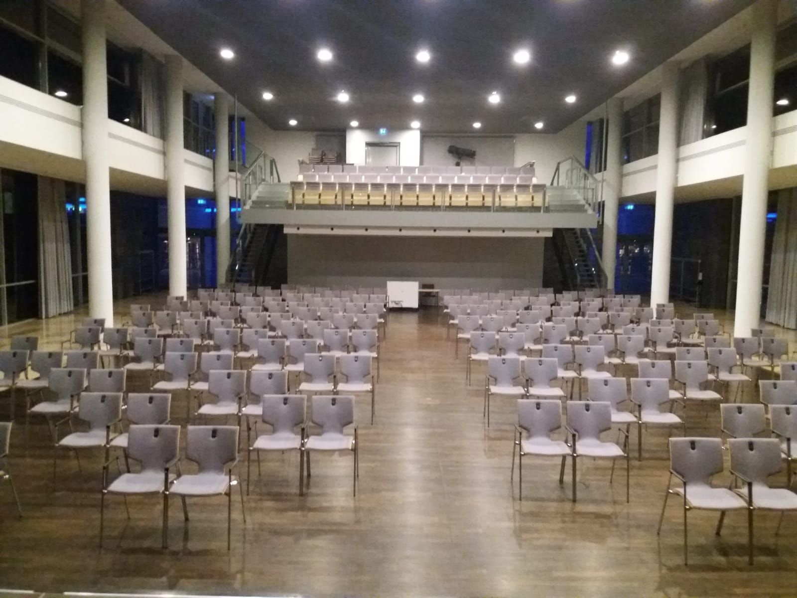 Blick von der Bühne auf den bestuhlten Raum und die Empore im Quellensaal