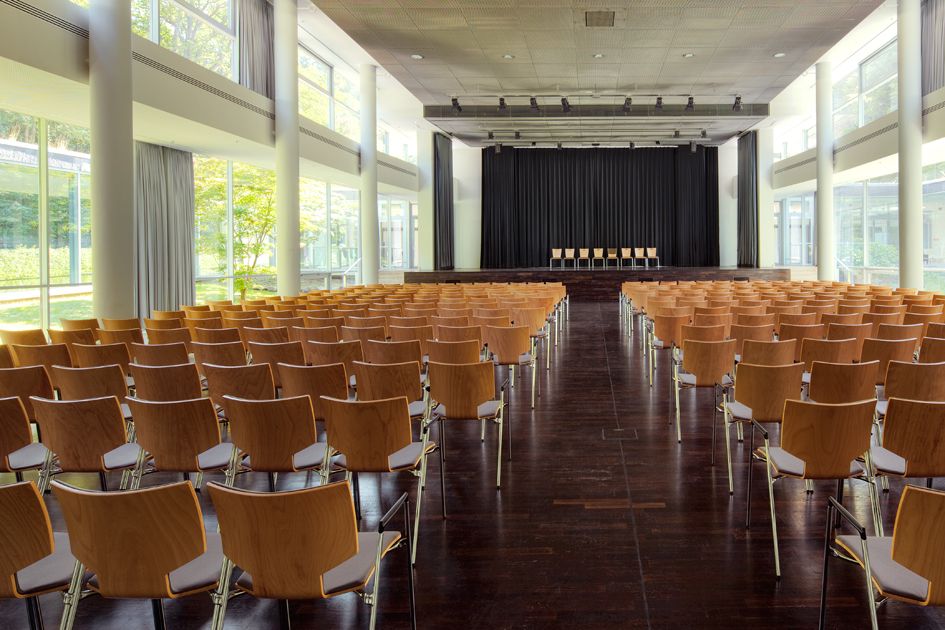 Blick auf Stuhlreihen und die Bühne im Quellensaal der Wandelhalle Bad Wildungen.