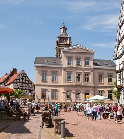 Blick auf das Rathaus in der Altstadt. Viele Menschen sitzen im Café und bummeln durch die Geschäfte