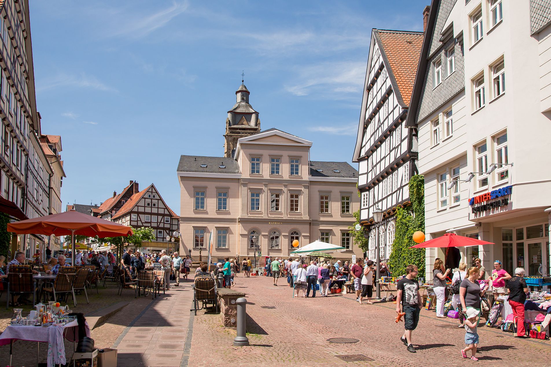 Blick auf das Rathaus in der Altstadt. Viele Menschen sitzen im Café und bummeln durch die Geschäfte