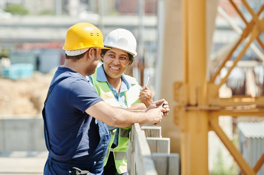 Zwei Bauarbeiter die sich auf einer Baustelle unterhalten.