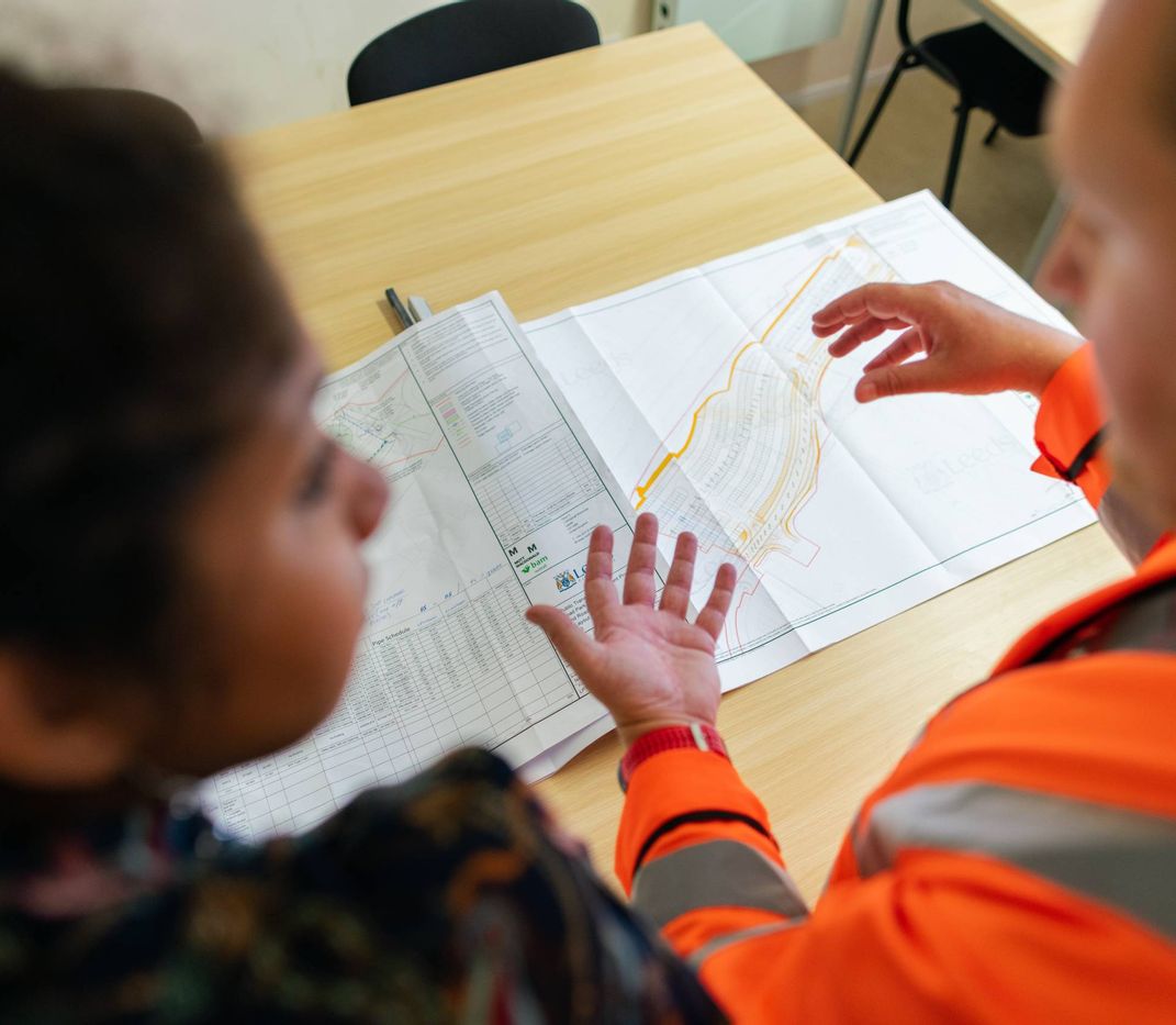 2 Personen sprechen über eine Bauplan.
