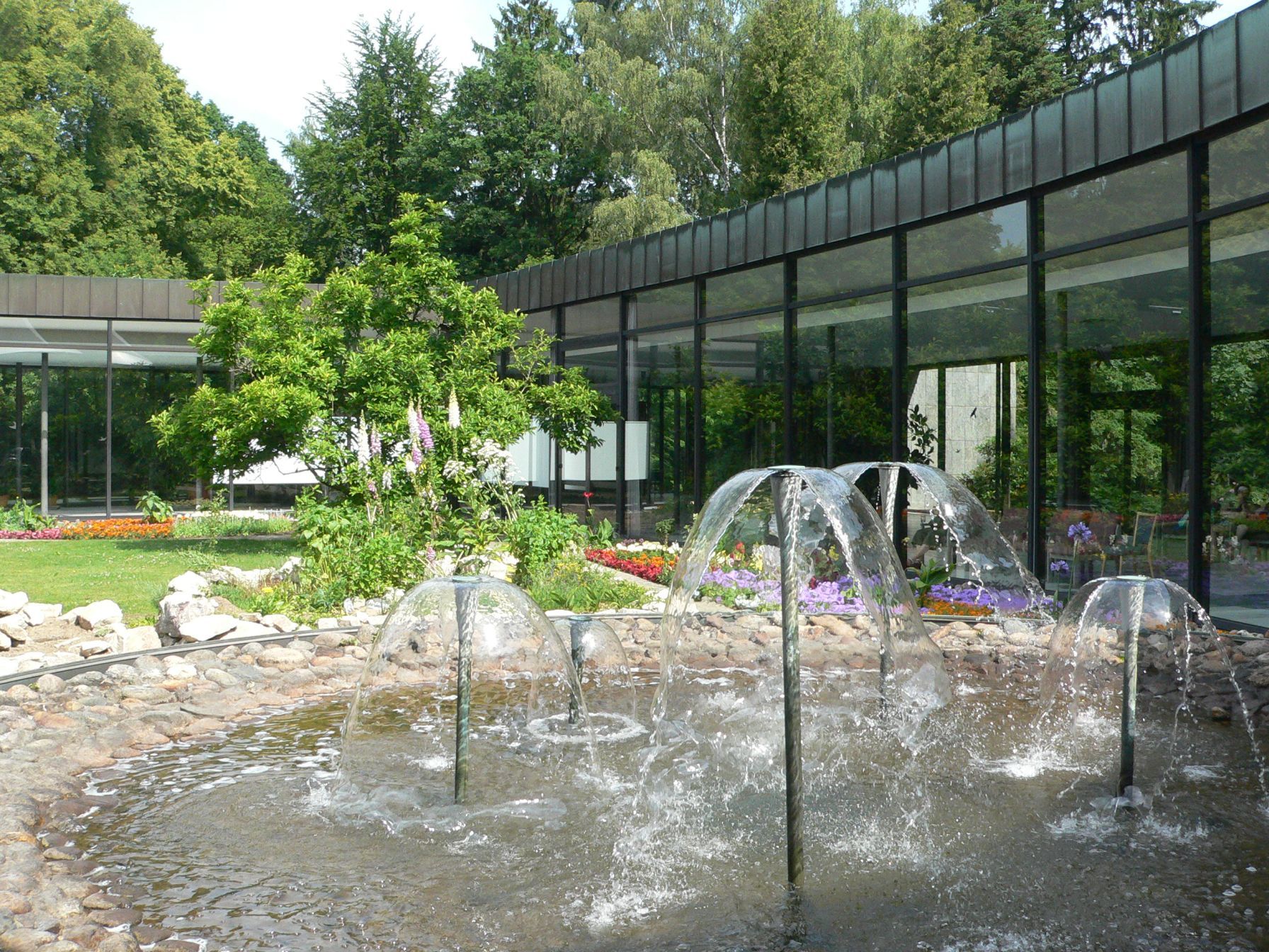 Bepflanztes Atrium mit kleinem Teich und Wasserfontänen in der Wandelhalle Reinhardshausen.