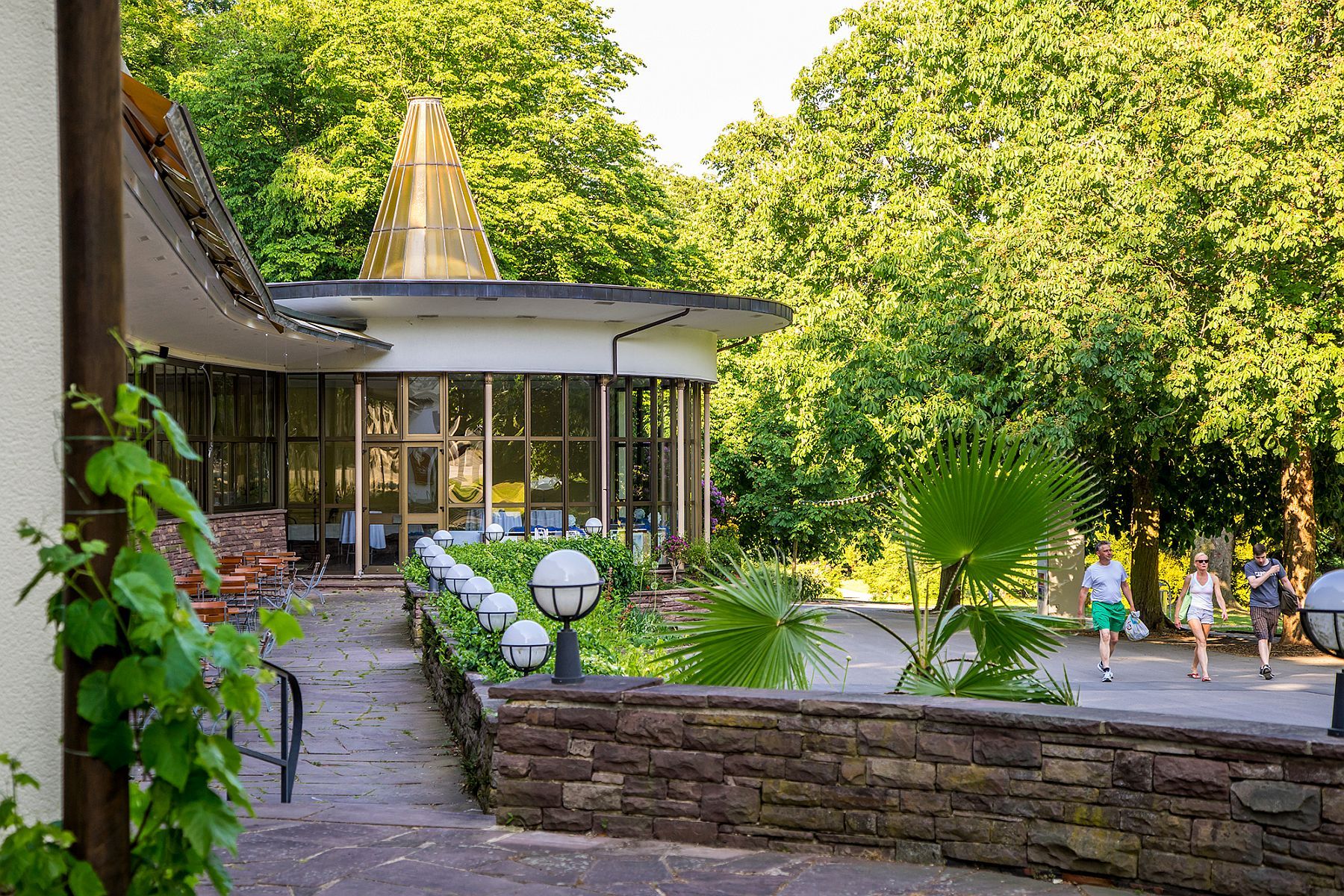 Blick auf die Terrasse und das Gebäude des Restaurants Mart-in im Kurpark Bad Widungens.
