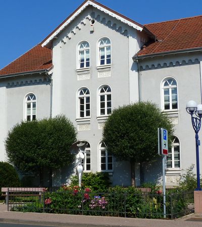 Außensicht des Gebäudes der Tourist-Information Bad Wildungens im Sommer bei blauem Himmel.