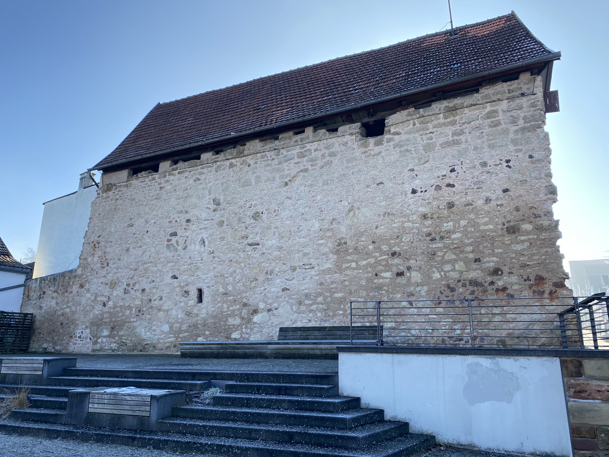 Blick auf den erhaltenen Teil des Lindentors zur Altstadt Bad Wildungen. Davor befindet sich eine Treppe mit Sitzmöglichkeiten.