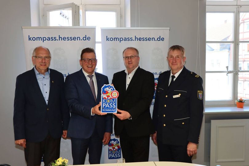 Der Bürgermeister hält neben 3 anderen Beamten das "Kompass"-Siegel in die Kamera