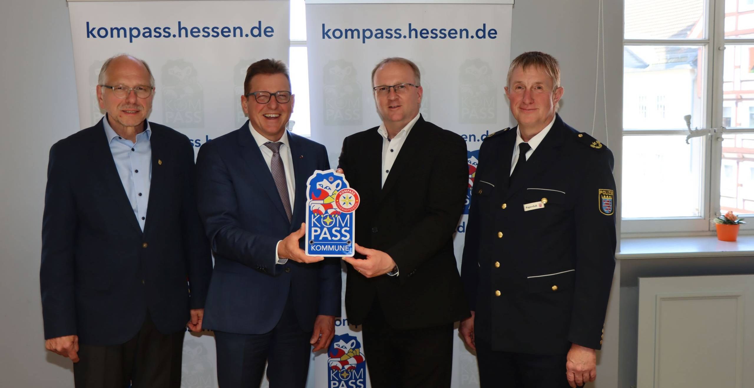 Der Bürgermeister hält neben 3 anderen Beamten das "Kompass"-Siegel in die Kamera