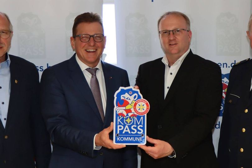 Der Bürgermeister hält neben 3 anderen Beamten das "Kompass"-Siegel in die Kamera