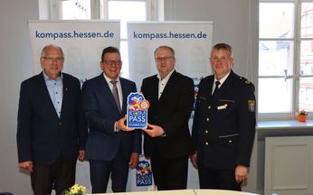 Der Bürgermeister hält neben 3 anderen Beamten das "Kompass"-Siegel in die Kamera