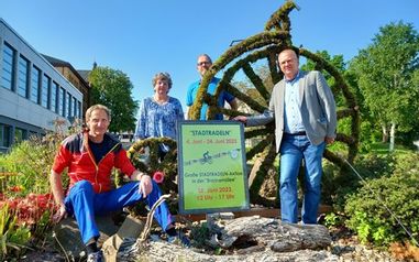 4 Personen die an einem großen, mit Moos bedeckten Fahrrad stehen. Davor eine Infotafel zum Stadtradeln.