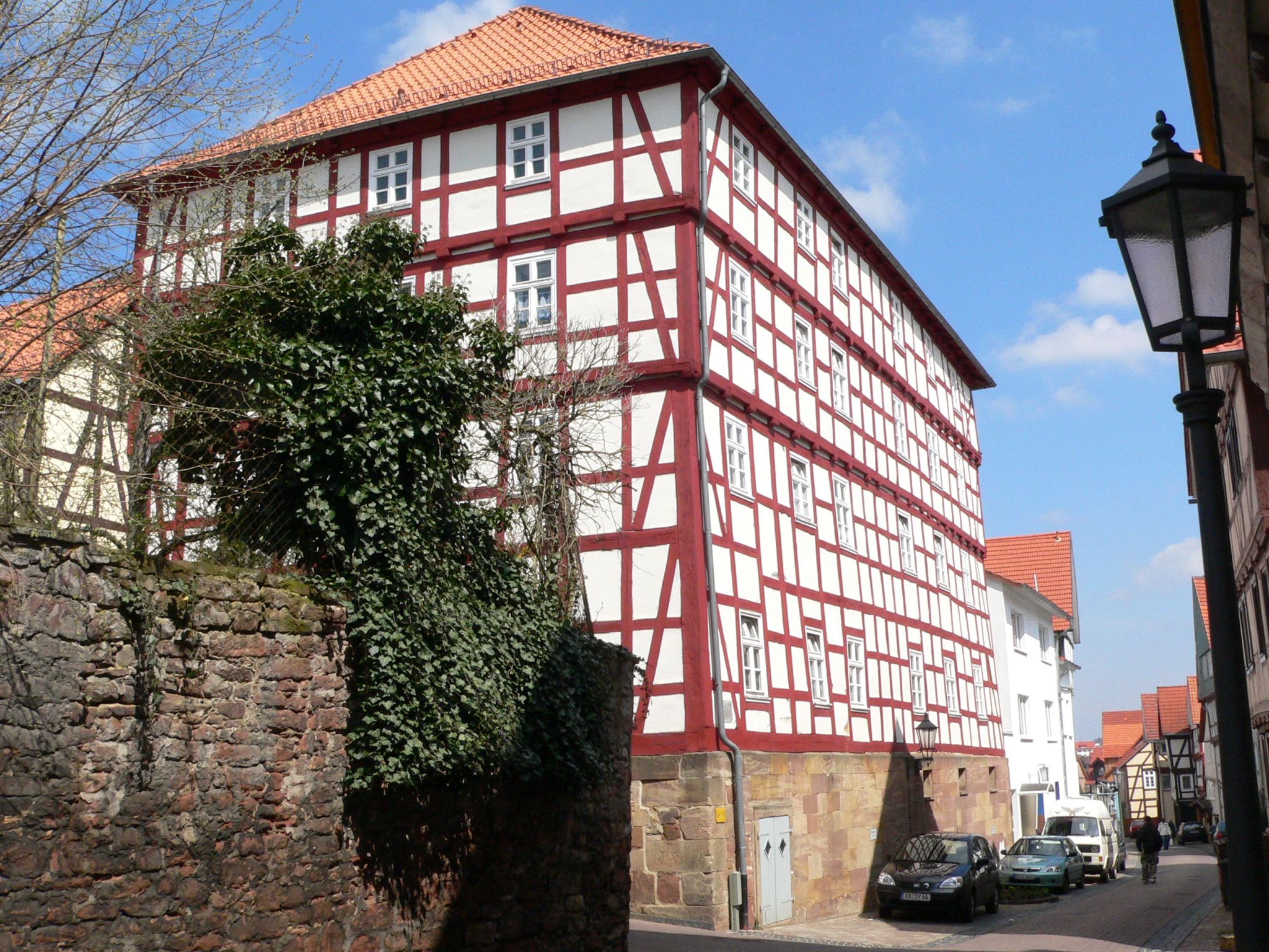 Außenaufnahme des ehemaligen Waisenhofs in der Altstadt. Zu sehen ist ein rot weißes Fachwerkhaus bei sonnigem Wetter sowie ein Teil der Straße in der es steht.