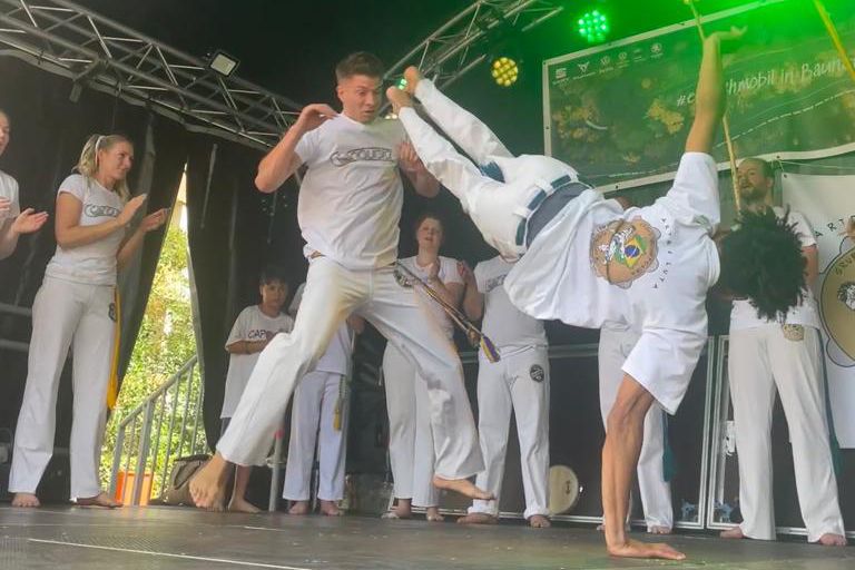 Die Sambagruppe Capoeira Grupo Conquista bei einem Auftritt am Tanzen.