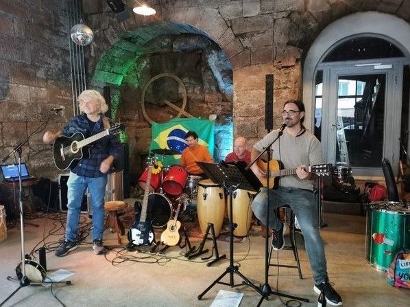 Die Gruppe Grupo Jurubeba bei einem Auftritt mit Trommeln und Gitarren.