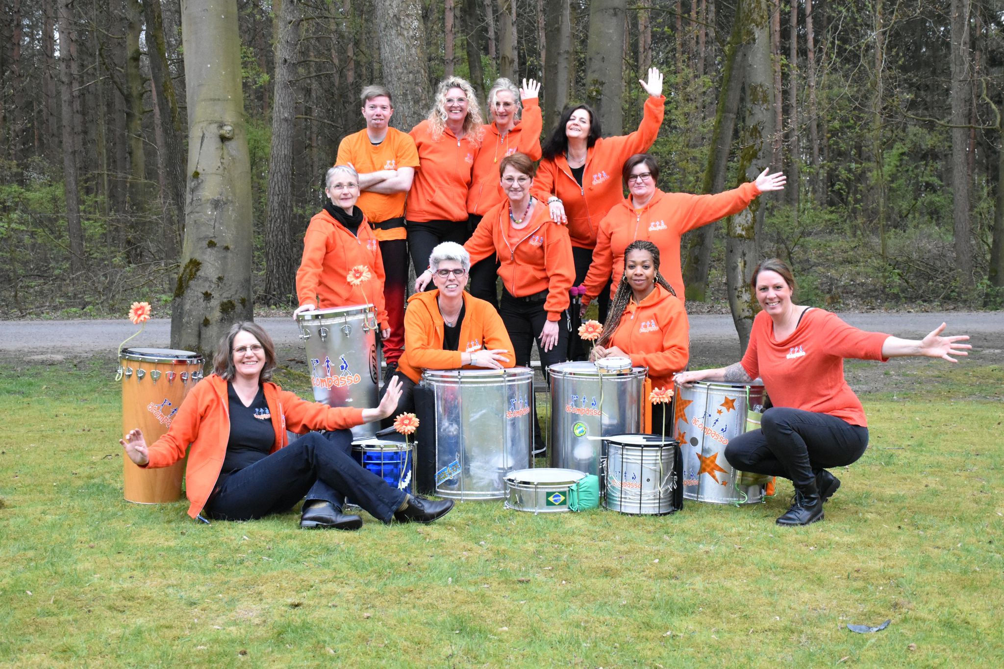 Die Samba-Gruppe acompasso mit ihren Trommeln auf einer Wieseo vor Bäumen.