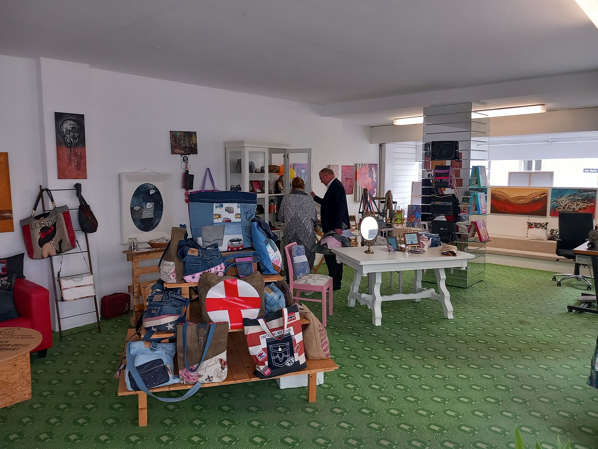 Der Bürgermeister und eine weitere Person im Pop-Up Store. Verkauft werden Taschen, Bilder und weitere Gegenstände.