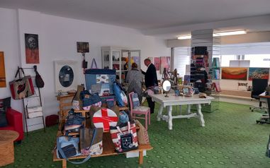 Der Bürgermeister und eine weitere Person im Pop-Up Store. Verkauft werden Taschen, Bilder und weitere Gegenstände.