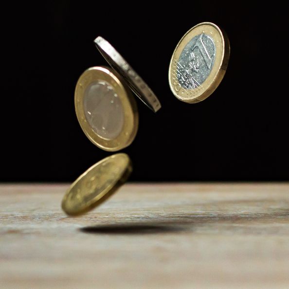 4 Münzen fallen aus ein paar Centimeter Höhe.