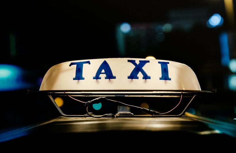 Eine leuchtende Lampe mit der Aufschrift "Taxi" in blau.