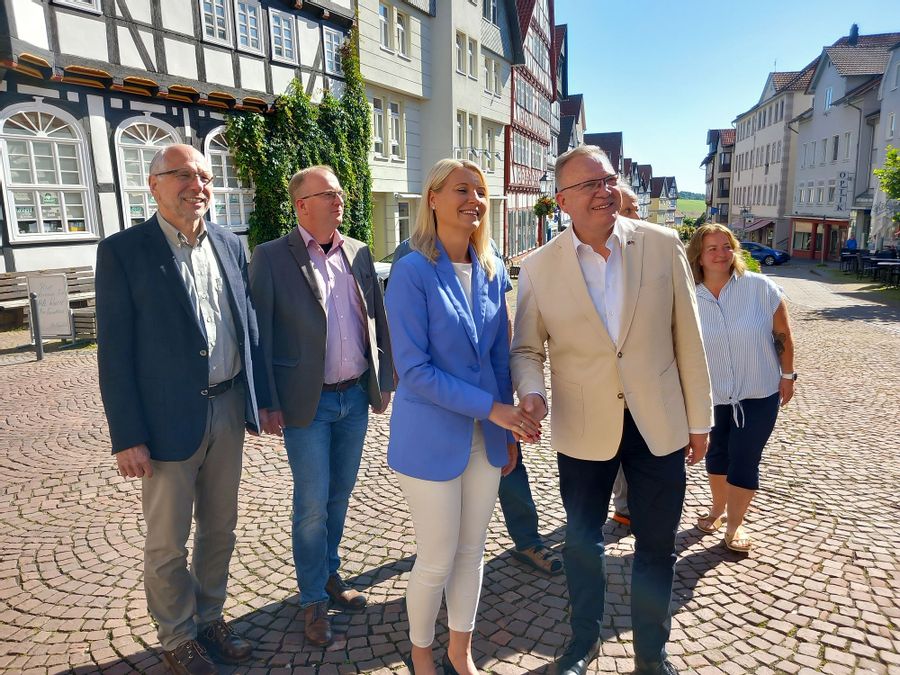 7 Personen stehen auf einer Straße in der Altstadt und blicken an der Kamera vorbei.